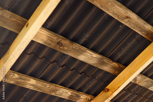 Brown ondulin roof background. The construction of the wooden roof. Detailed photo of a wooden roof overlap construction photo