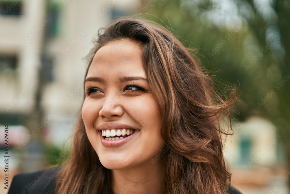 Young hispanic woman smiling happy standing at the city.