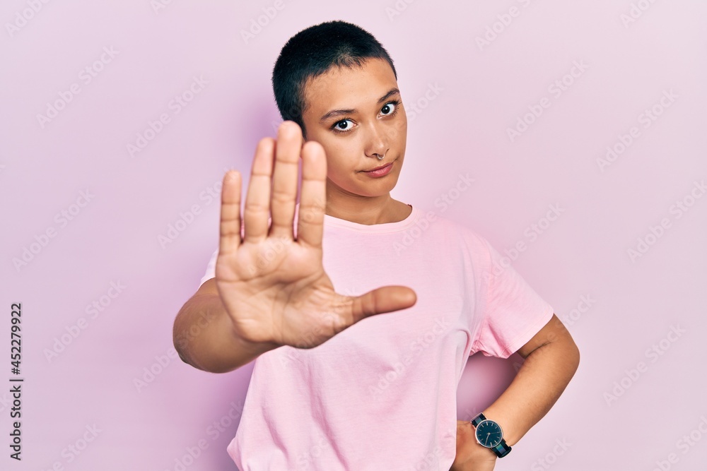 Beautiful hispanic woman with short hair wearing casual pink t shirt moving away hands palms showing refusal and denial with afraid and disgusting expression. stop and forbidden. Beautiful hispanic woman with short hair wearing casual pink t shirt moving away hands palms showing refusal and denial with afraid and disgusting expression. stop and forbidden.