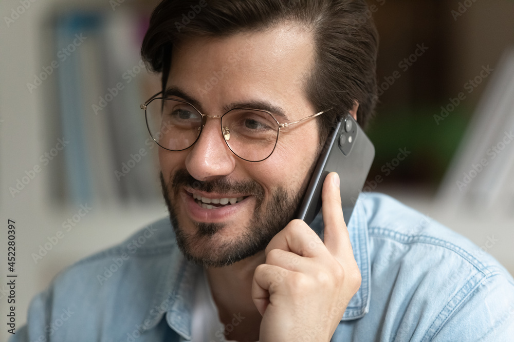 Handsome male office manager talk to client on cellphone, close up portrait. Businessman sit at workplace holding smartphone near ear solve business by phonecall. Modern tech usage, connection concept Handsome male office manager talk to client on cellphone, close up portrait. Businessman sit at workplace holding smartphone near ear solve business by phonecall. Modern tech usage, connection concept