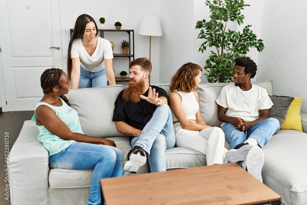 Group of young friends smiling happy sitting on the sofa at home. Group of young friends smiling happy sitting on the sofa at home.