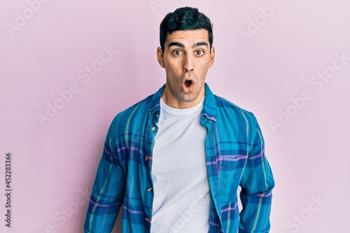Handsome hispanic man wearing casual clothes afraid and shocked with surprise expression, fear and excited face.