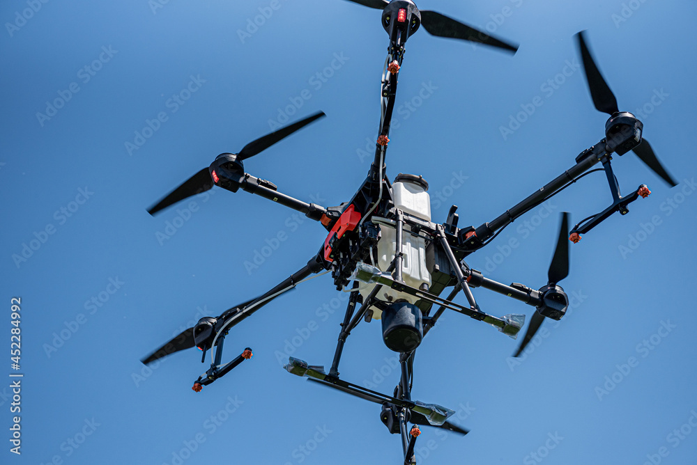 Professional agriculture drone flying in the blue sky Professional agriculture drone flying in the blue sky