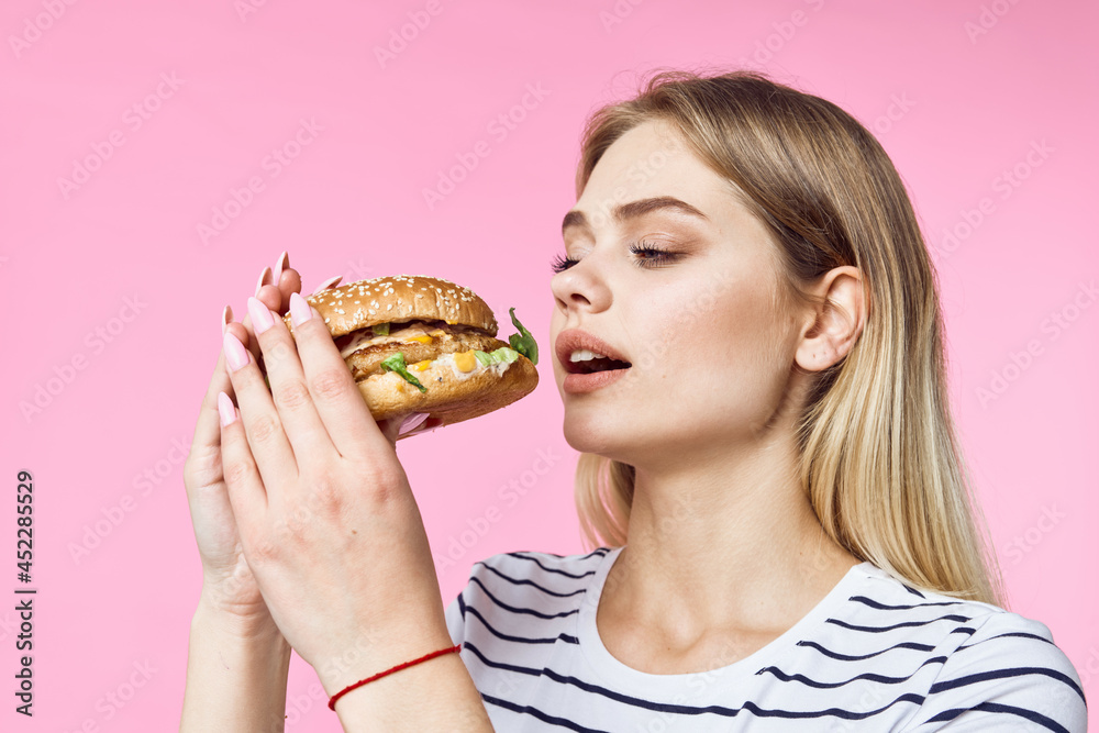 woman in striped t-shirt hamburger delicious sandwich snack pink background woman in striped t-shirt hamburger delicious sandwich snack pink background