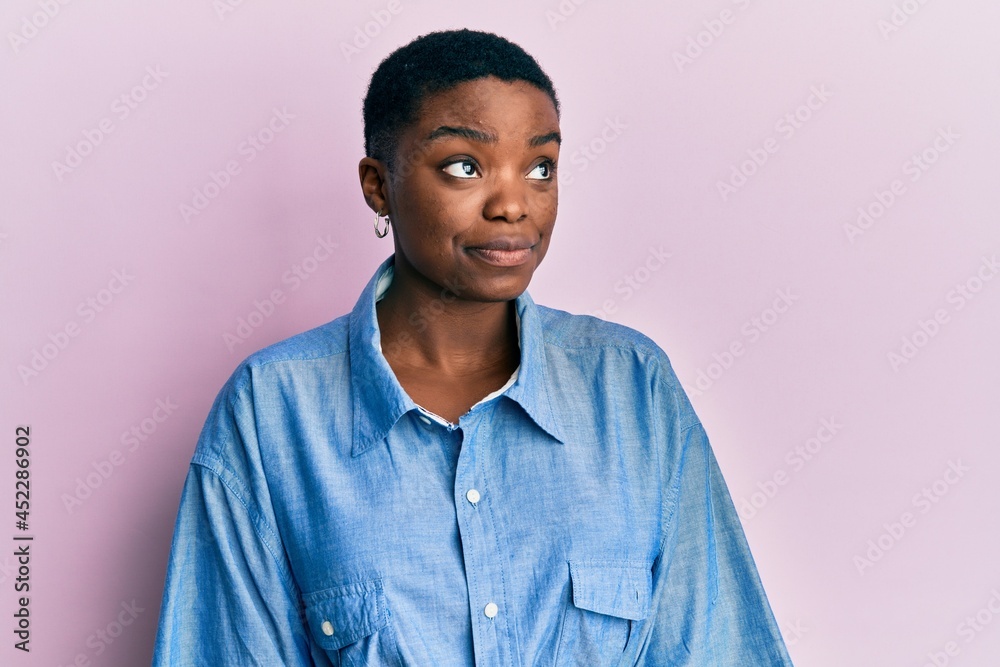 Young african american woman wearing casual clothes smiling looking to the side and staring away thinking. Young african american woman wearing casual clothes smiling looking to the side and staring away thinking.