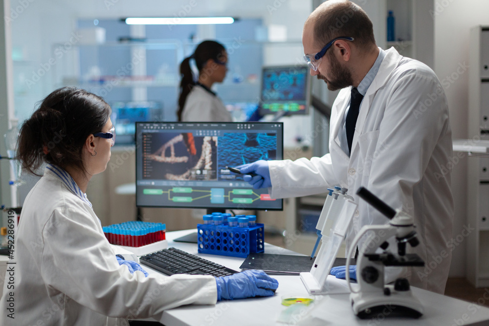 Medical biologist team working in microbiology hospital laboratory ...