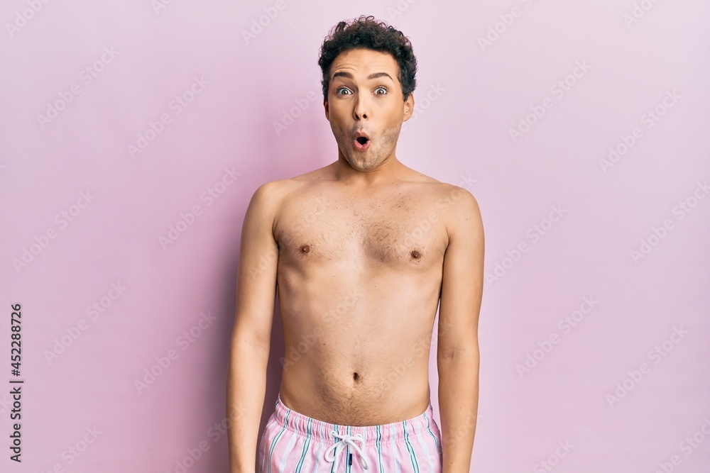 Fototapeta premium Young handsome man wearing swimwear shirtless afraid and shocked with surprise expression, fear and excited face.