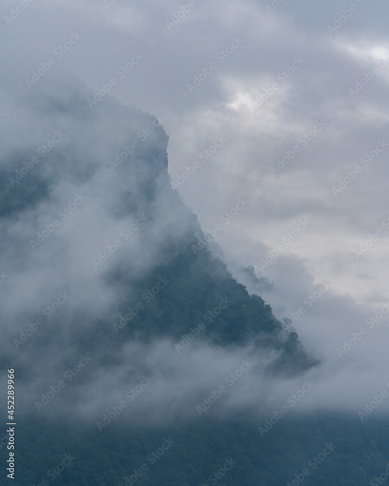 Dreamy landscape view of forested mountain shrouded in clouds, Chiang Dao, Chiang Mai, Thailand