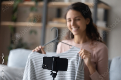 Latina woman fashion blogger recording video blog on smartphone, focus on cellphone. Sharing shopping opinion, own brand online internet store promotion. Advertisement, influence, videovlog concept