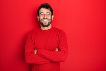 Handsome man with beard wearing casual red sweater happy face smiling with crossed arms looking at the camera. positive person.