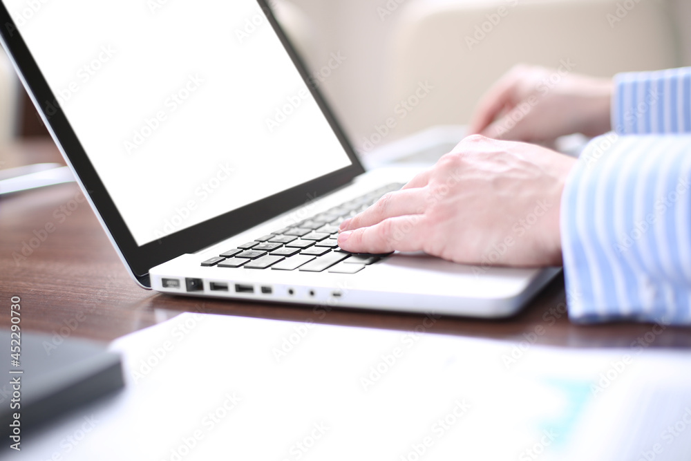 Businessman working in modern cretive studio. Using generic design laptop.