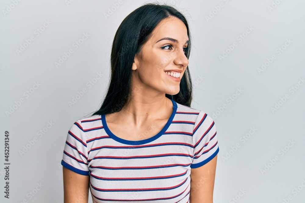 Young hispanic woman wearing casual clothes looking to side, relax profile pose with natural face and confident smile. Young hispanic woman wearing casual clothes looking to side, relax profile pose with natural face and confident smile.
