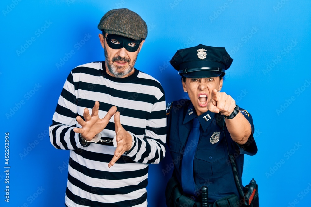 Φωτογραφία Middle age couple of hispanic woman and man wearing thief and police uniform poi
