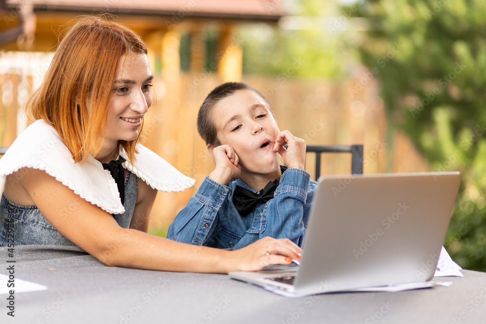 Boy studying from home in an online classroom in the new normal. Schoolboy listens to a lecture and solves problems Boy studying from home in an online classroom in the new normal. Schoolboy listens to a lecture and solves problems