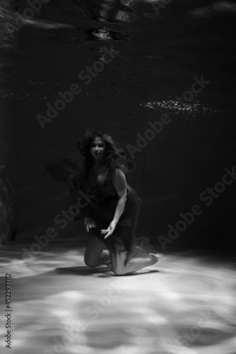 Beautiful girl underwater in the pool. Black and white photography  creative and mystical