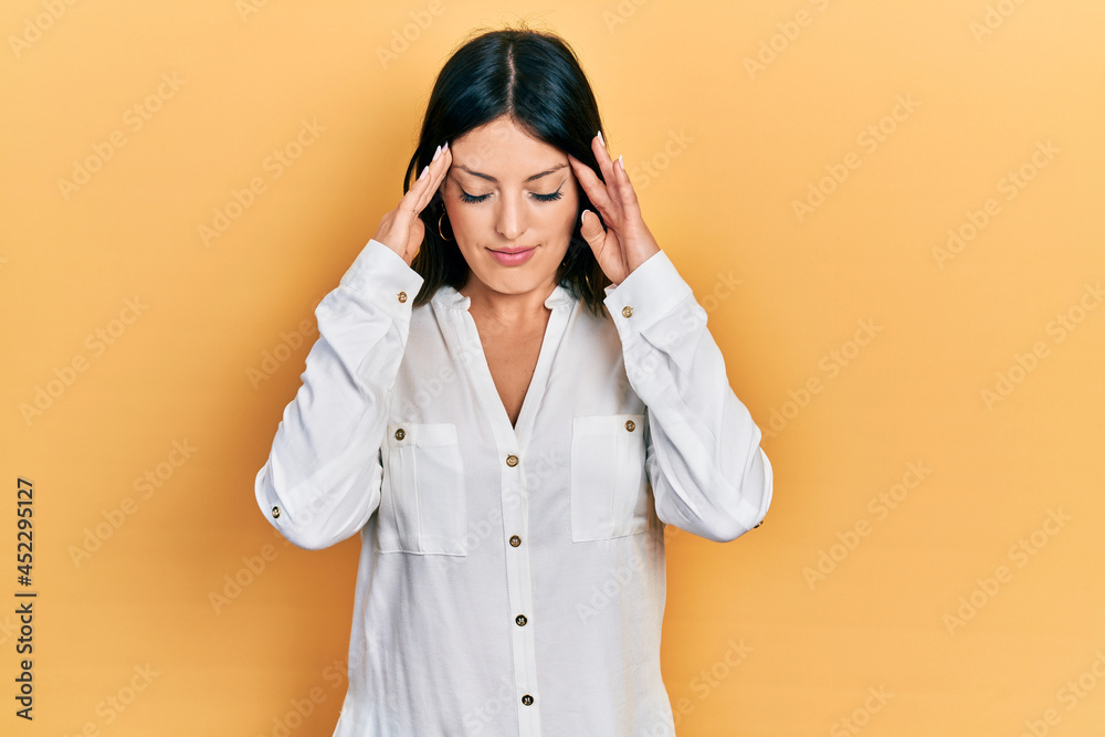 Young hispanic woman wearing casual clothes with hand on head for pain in head because stress. suffering migraine. Young hispanic woman wearing casual clothes with hand on head for pain in head because stress. suffering migraine.