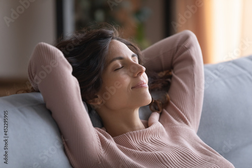 Free Download Smiling serene Hispanic woman close her eyes put hands behind head breath fresh conditioned air inside of modern living room, enjoy stress-free day off alone at home. Daydreams, peace of mind concept - GFXLoad