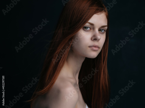 red-haired woman naked shoulders dark background glamor