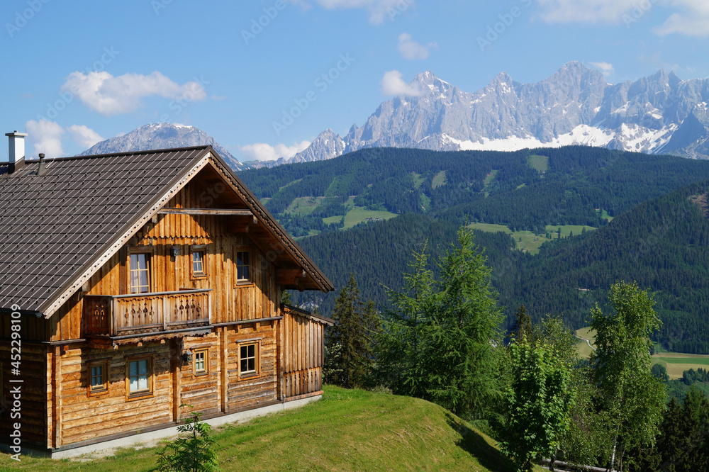 scenic alpine panorama with an alpine log cabin and Dachstein mountain in the background in the Austrian Alps of the Schladming-Dachstein region (Almwelt Austria (Reiteralm Chalets))