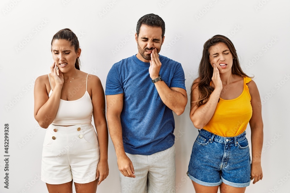 Group of young hispanic people standing over isolated background touching mouth with hand with painful expression because of toothache or dental illness on teeth. dentist Group of young hispanic people standing over isolated background touching mouth with hand with painful expression because of toothache or dental illness on teeth. dentist