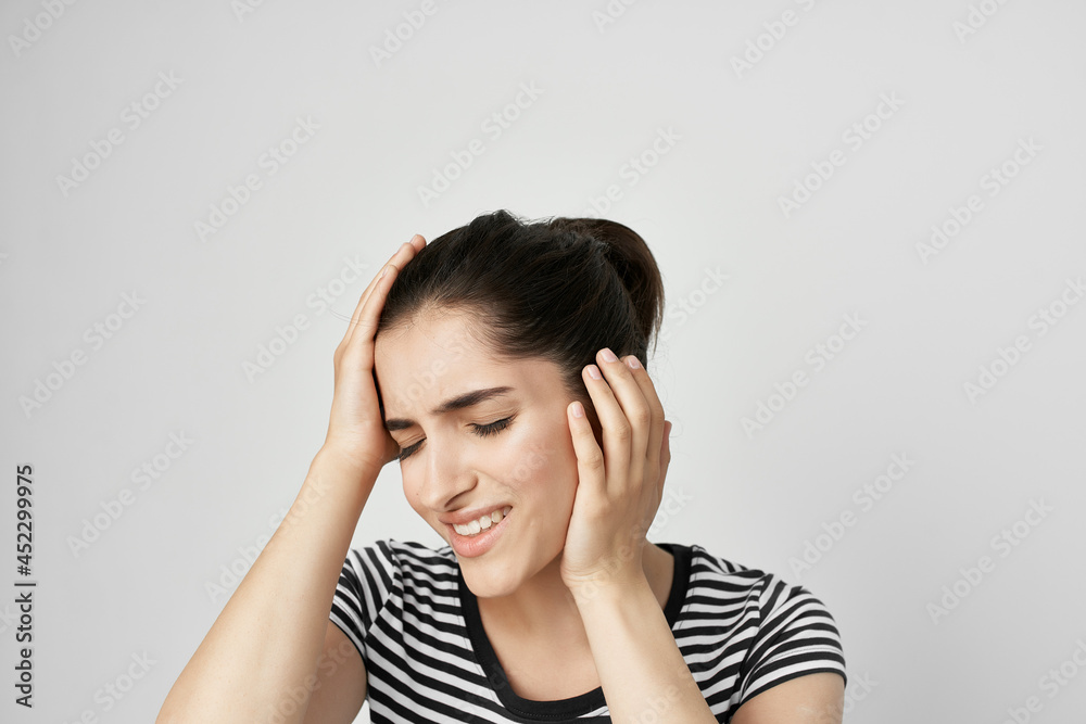 woman in striped t-shirt holds face pain in teeth dentist treatment woman in striped t-shirt holds face pain in teeth dentist treatment