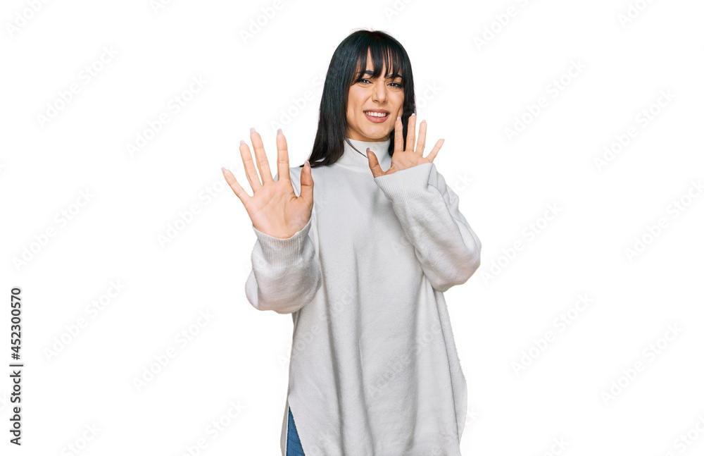 Young brunette woman with bangs wearing casual turtleneck sweater afraid and terrified with fear expression stop gesture with hands, shouting in shock. panic concept. Young brunette woman with bangs wearing casual turtleneck sweater afraid and terrified with fear expression stop gesture with hands, shouting in shock. panic concept.
