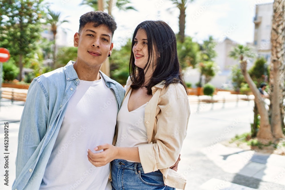 Naklejka premium Young hispanic couple of boyfriend and girlfriend together outdoors on a sunny day