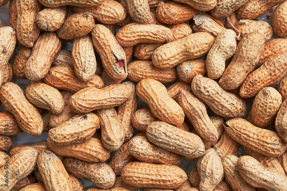 Healthy roasted unpeeled peanuts. Brown nuts texture