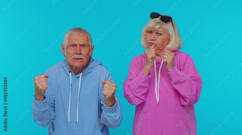 Upset frustrated annoyed senior stylish grandparents pensioners raising hands in indignant expression, quarreling, asking reason of conflict, why such stubborn. Elderly mature grandfather grandmother Upset frustrated annoyed senior stylish grandparents pensioners raising hands in indignant expression, quarreling, asking reason of conflict, why such stubborn. Elderly mature grandfather grandmother