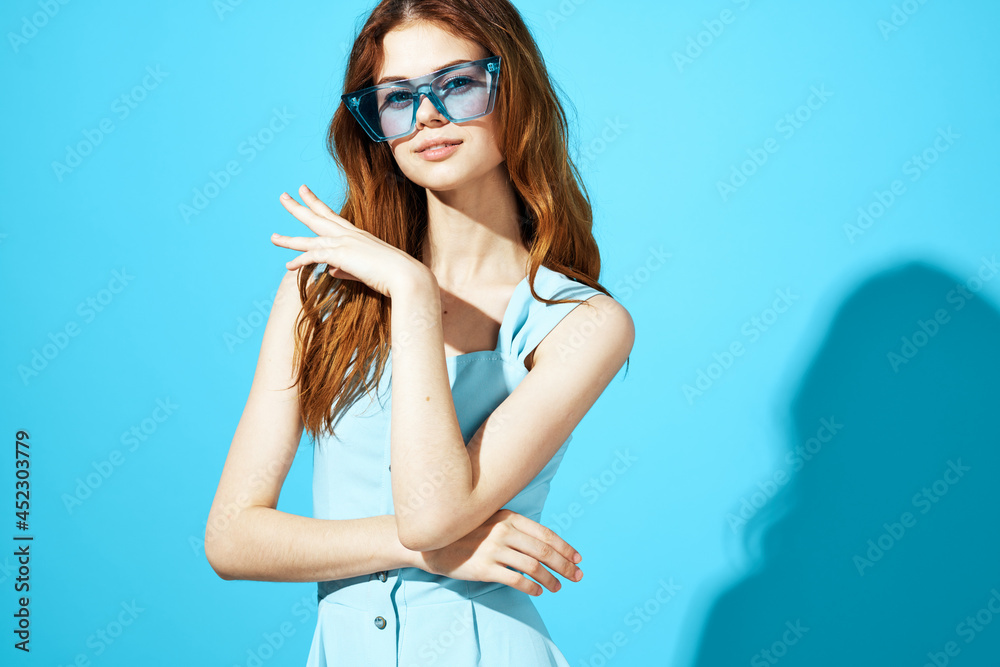 beautiful woman in fashionable glasses blue background Lifestyle