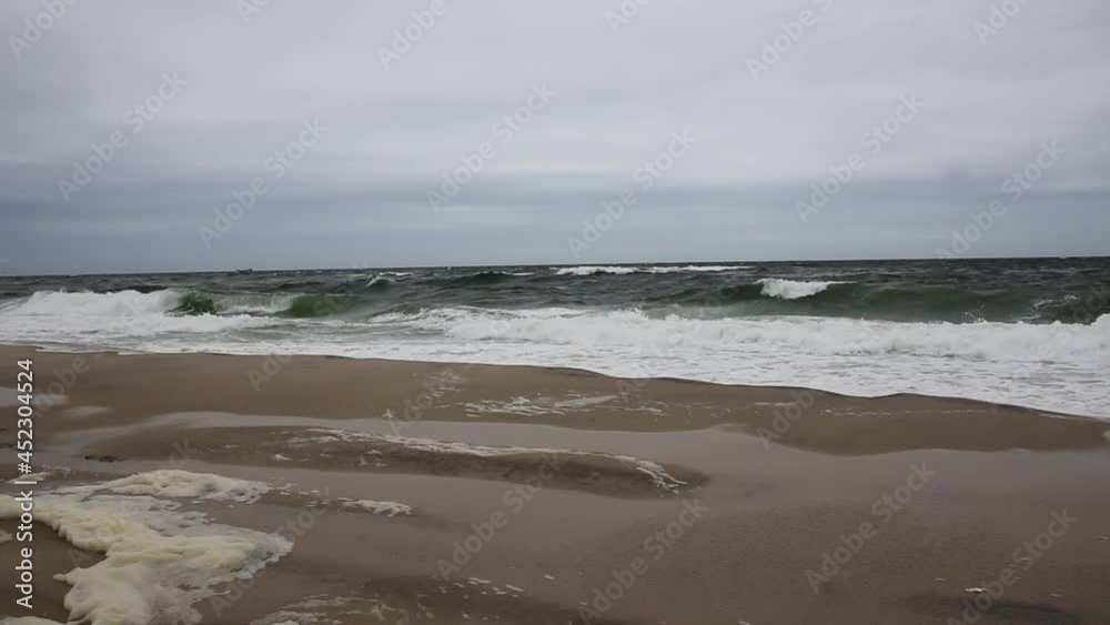 Wide view of rough ocean waves landing on the beach leaving sea foam and erosion due to a strom off shore. Wide view of rough ocean waves landing on the beach leaving sea foam and erosion due to a strom off shore.