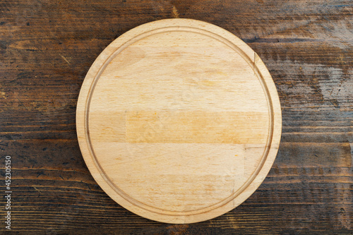 Round cutting board on a wooden table. Space for text.