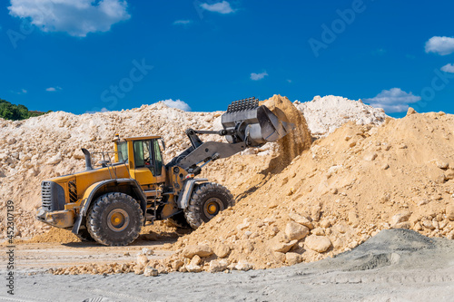 Front end loader in operation  dumping limestone 