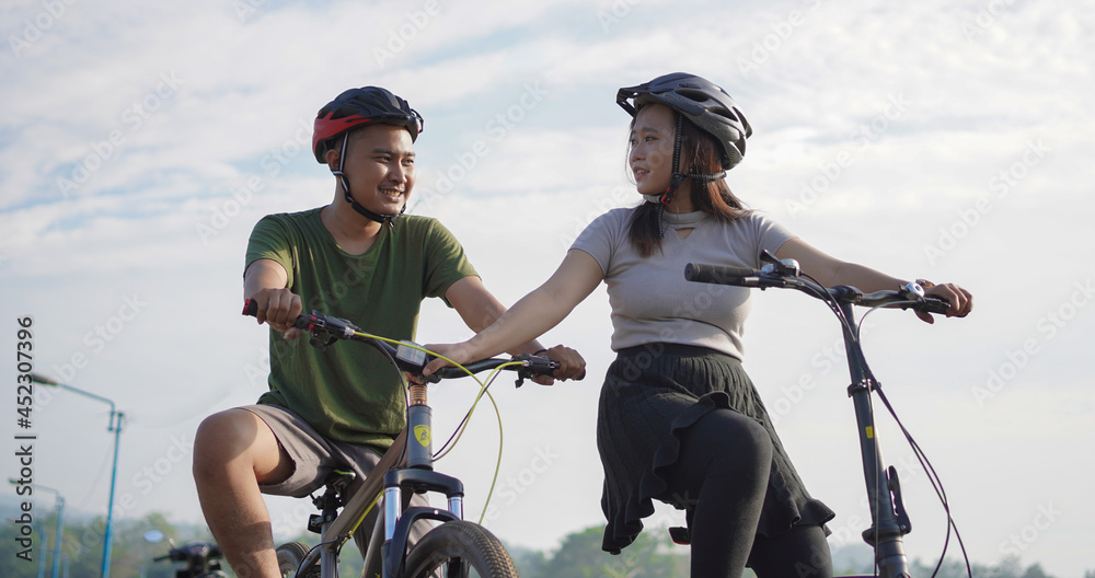 young asian couple ride bicycle in the morning