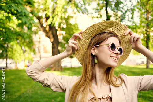 woman sunglasses and a hat in the park green grass model