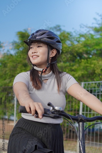 young asian woman enjoying cycling when stopped in summer morning