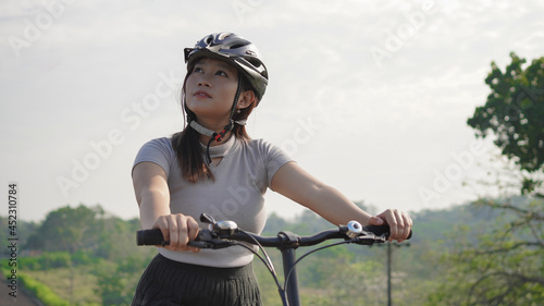 young asian woman enjoying cycling and scenery in summer morning