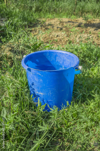 Old plastic bucket with water in nature