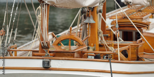 Expensive retro sailing boat (ketch) moored to a pier in a new yacht marina. Wooden teak deck, elegant details. Transportation, nautical vessel, vacations, tourism, cruising, regatta, recreation photo