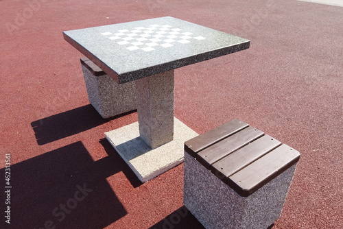 Concrete chess table for outdoor play. Chess playground in the city park. Contemporary concrete architecture and public space decoration