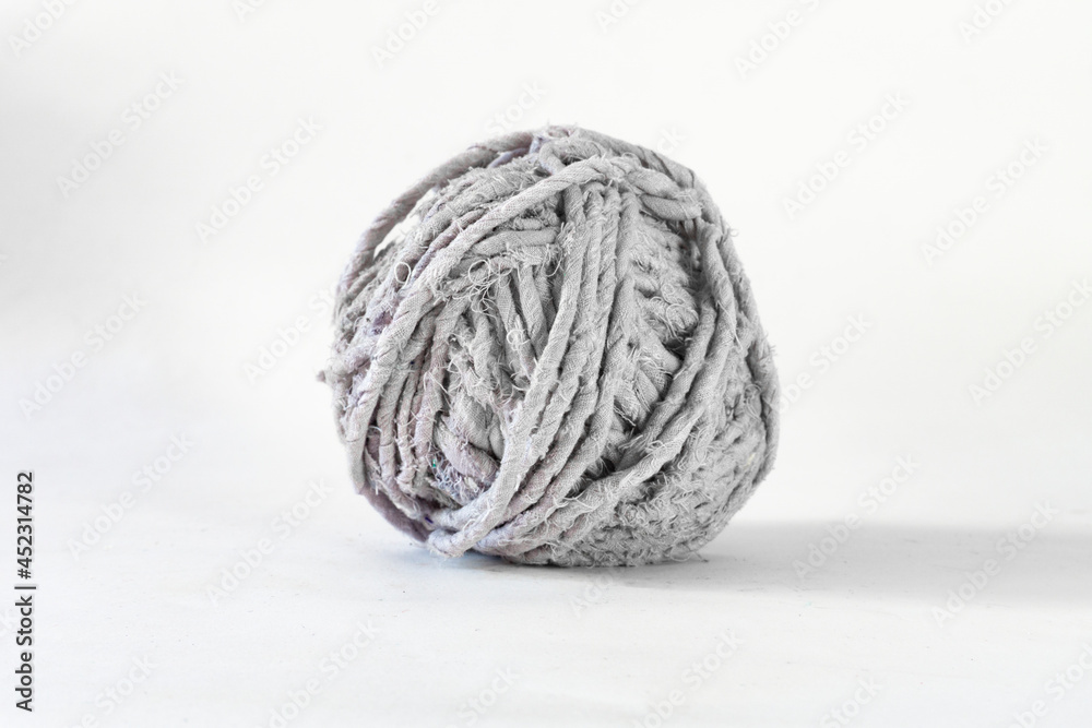 Side view of a grey thread ball of recycled textiles Side view of a grey thread ball of recycled textiles