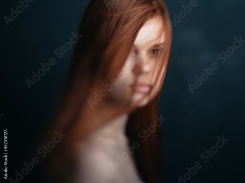 attractive red-haired woman naked shoulders clear skin dark background