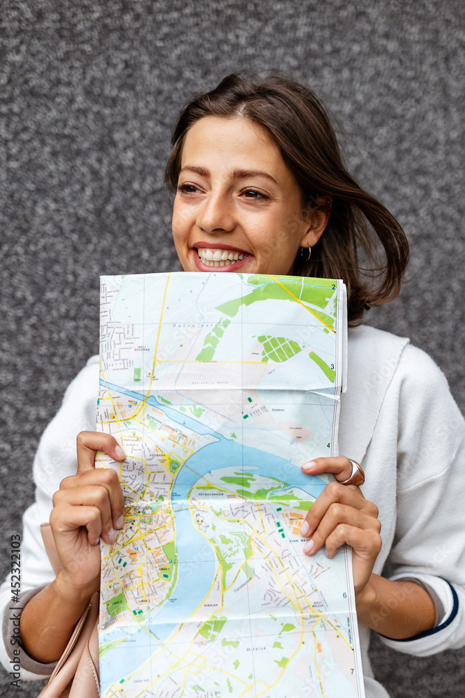 Happy young woman traveler with backpack and map on the street. Happy young woman traveler with backpack and map on the street.