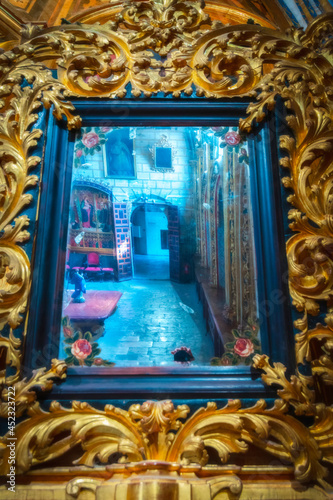 Detail view of the reflection of a mirror with carved wooden forms in the interior chapel of the old religious cathedral of Cuenca, a World Heritage city, Spain.