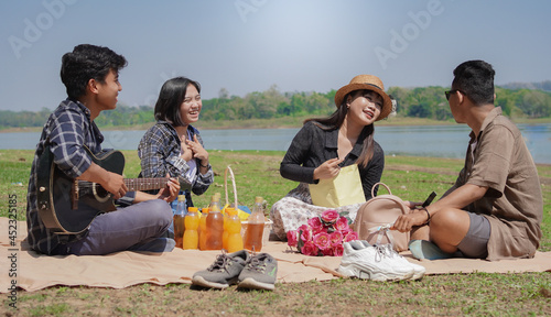 Young people talking and laughing together while having a vacation in the park