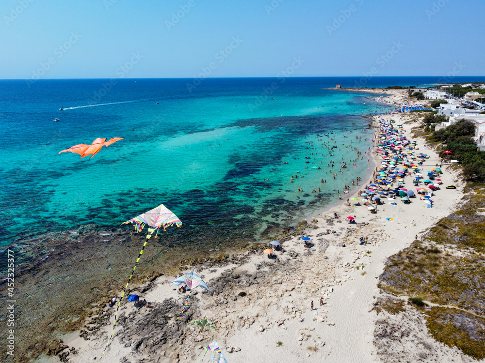 Obraz premium Aerial View of a Group of Kites on Italian Beach in Summer in a Sunny Day on Beach Umbrellas Background..