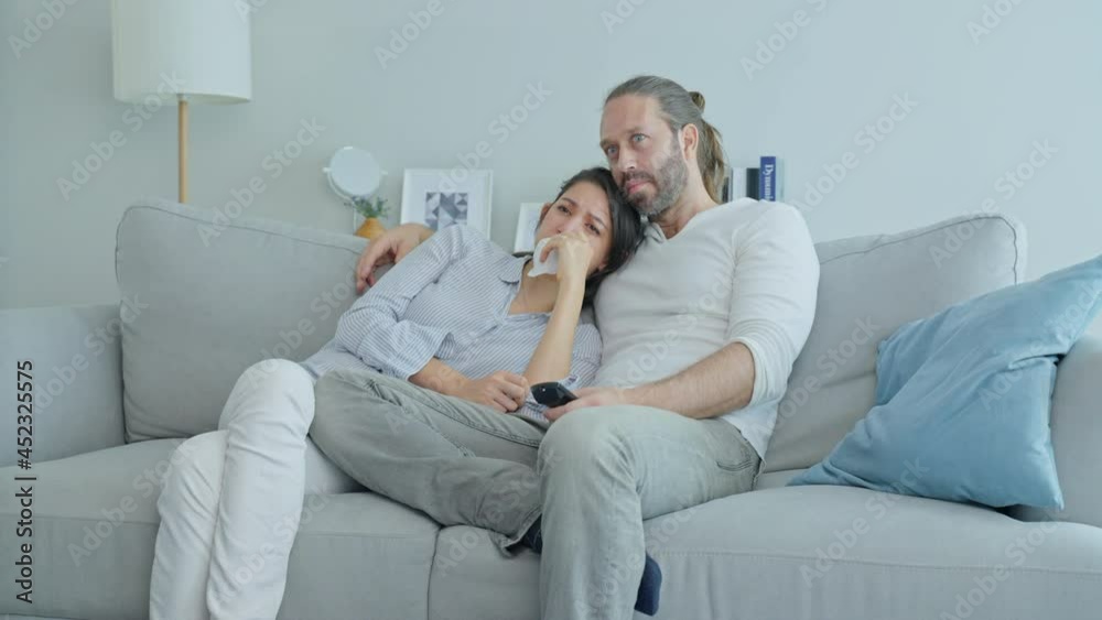 Caucasian loving couple watch movie together in living room at home. 