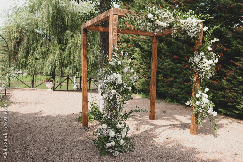 Rustic wedding arch for an ceremony decorated with white and flowers. Rustic wedding arch for an ceremony decorated with white and flowers.