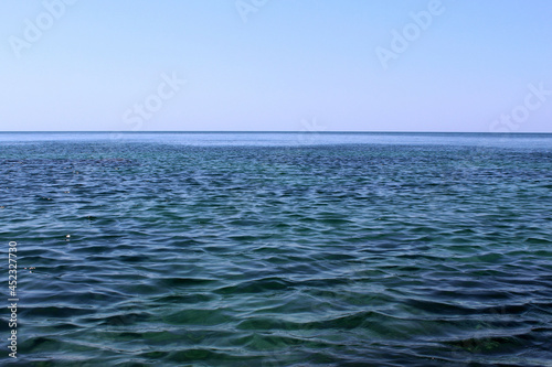 The calm sea stretches to the horizon with a cloudless sky.