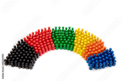 wooden figurines in the colors of German political parties and the rotunda of the german parliament